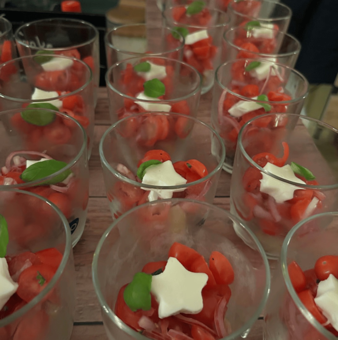 Kleine Gläser mit gehackten Tomaten, Zwiebeln, Basilikum und sternförmigem Käse