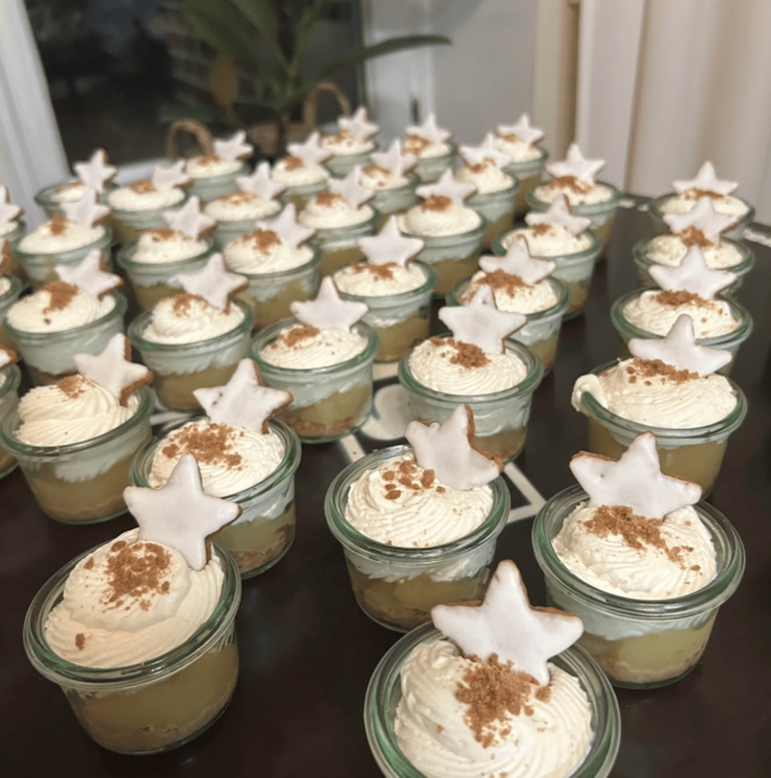 Viele kleine Dessertgläser mit Sahne, Zimt und Sternplätzchen
